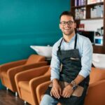 Smiling man in apron on chair