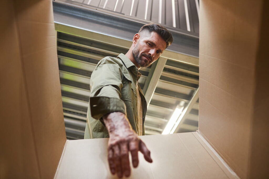 Man reaching into a cardboard box.