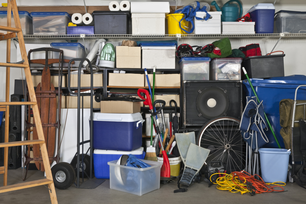 A collection of speakers, boxes, and other items in a self storage unit.