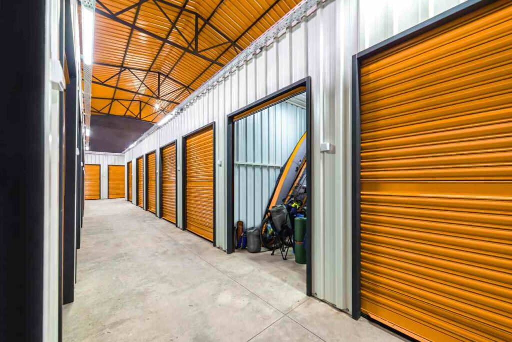 Corridor of self storage units with orange doors.