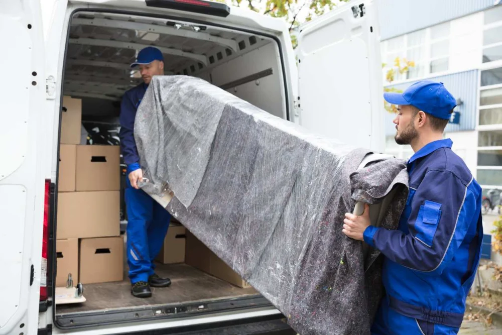 Two men moving furniture into a van